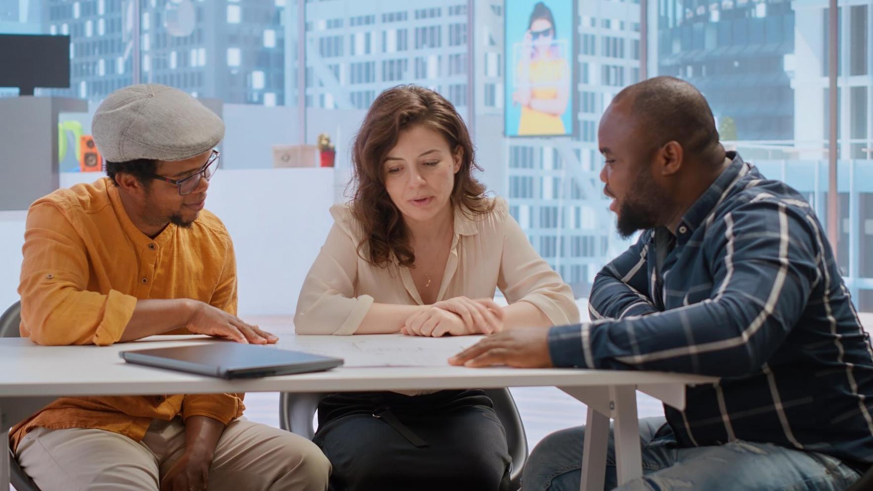 Espace de travail collaboratif chez plefyreniq avec écrans affichant des tableaux de bord d'investissement